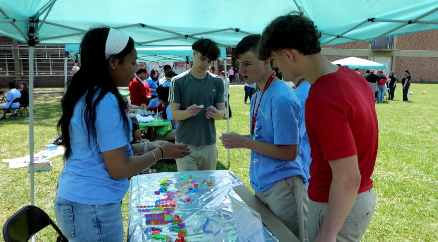 People talking around the community connections project booth.